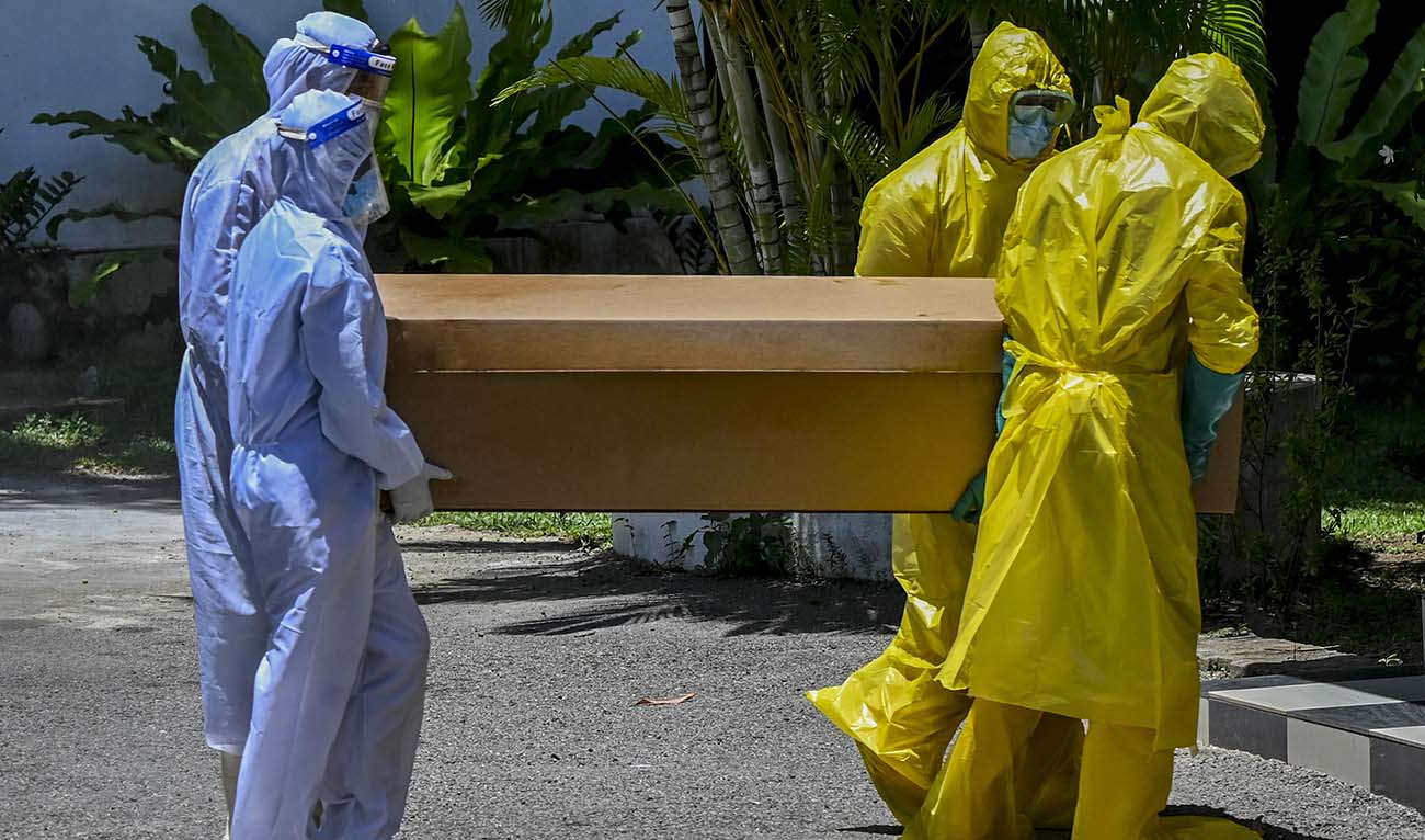 Workers carry a cardboard coffin of a Covid-19 coronavirus victim for cremation at a cemetery in Colombo on August 31, 2021. (AFP/File)