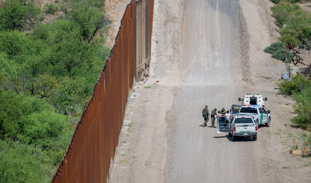 A group of migrants are apprehended by U.S. Customs and Border protection officers after crossing over into the U.S. on June 26, 2024 in Ruby, Arizona. (AFP/File)