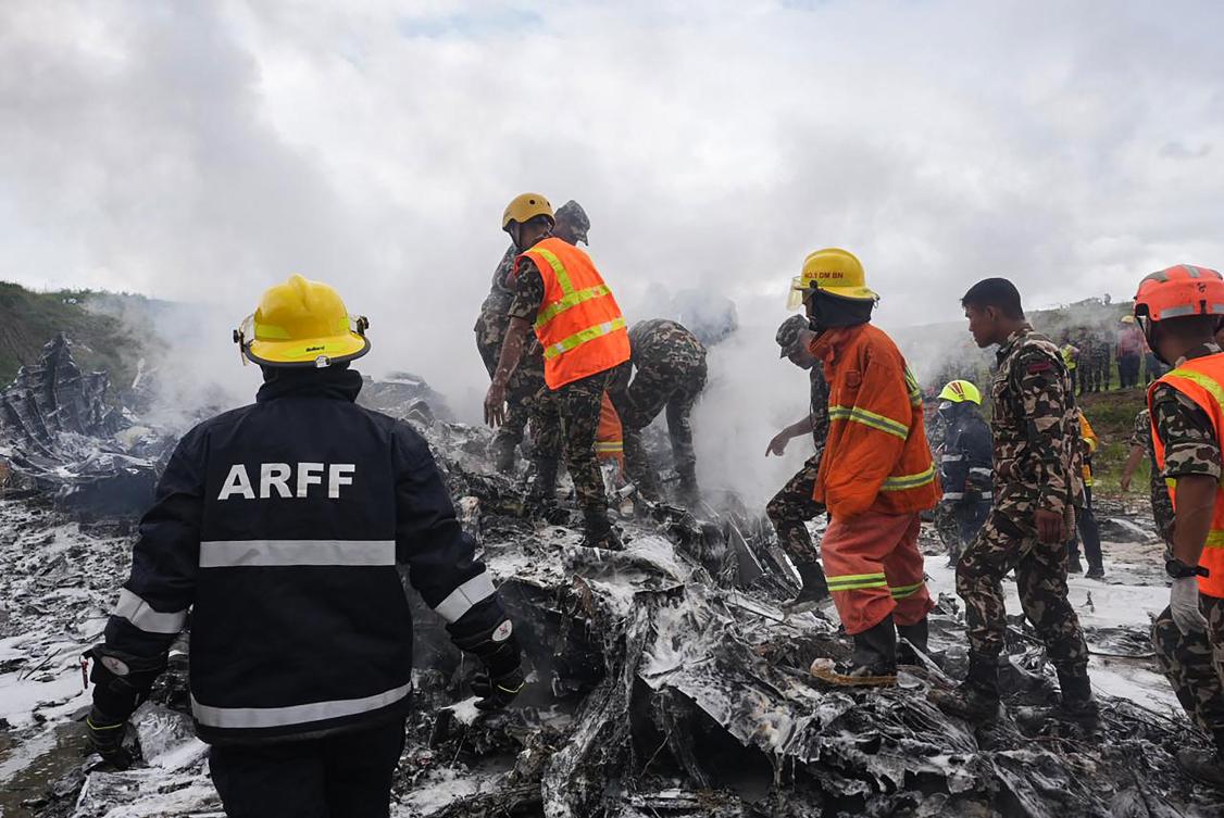 Rescuers and army personnel stand at the site after a Saurya Airlines’ plane crashed during takeoff at Tribhuvan International Airport in Katmandu on July 24, 2024. (AFP)