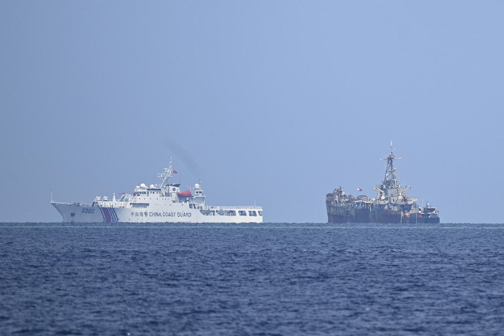 China has long been irked by the Philippine missions to its small contingent of troops aboard the rusty ship Sierra Madre, right, which was intentionally run aground in 1999 to try to reinforce Manila’s territorial claim to the remote shoal. (AFP)
