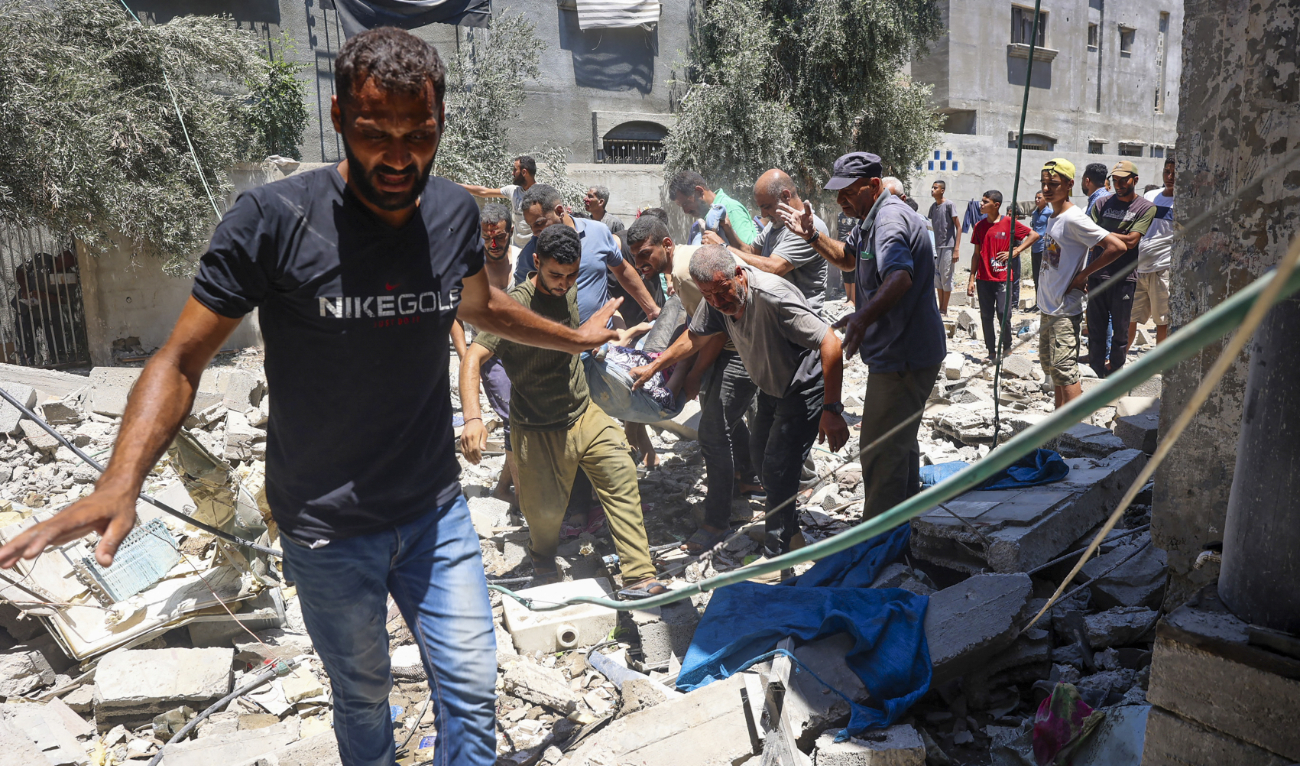 People carry a person injured during Israeli bombardment at Al-Bureij refugee camp in the central Gaza Strip on July 23, 2024. (AFP)