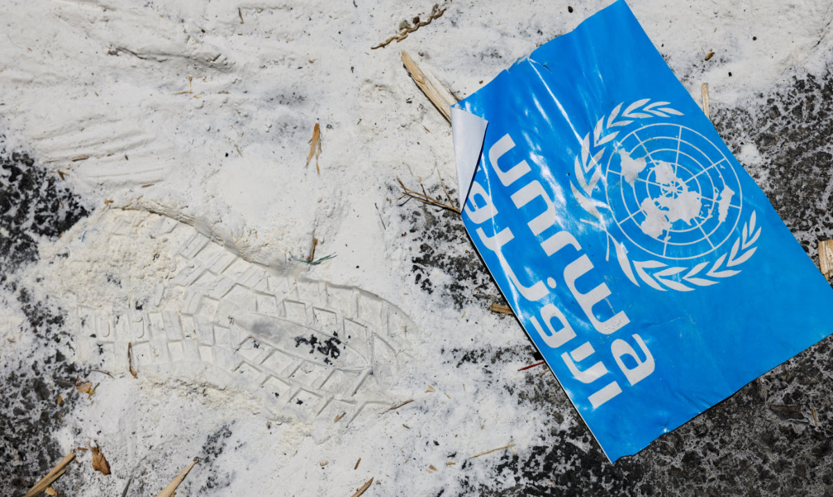 A United Nations Relief and Works Agency (UNRWA) sign lies on the ground, amid the ongoing conflict in Gaza between Israel and the Palestinian Islamist group Hamas, at the Kerem Shalom crossing in southern Israel, May 30, 2024. (Reuters)