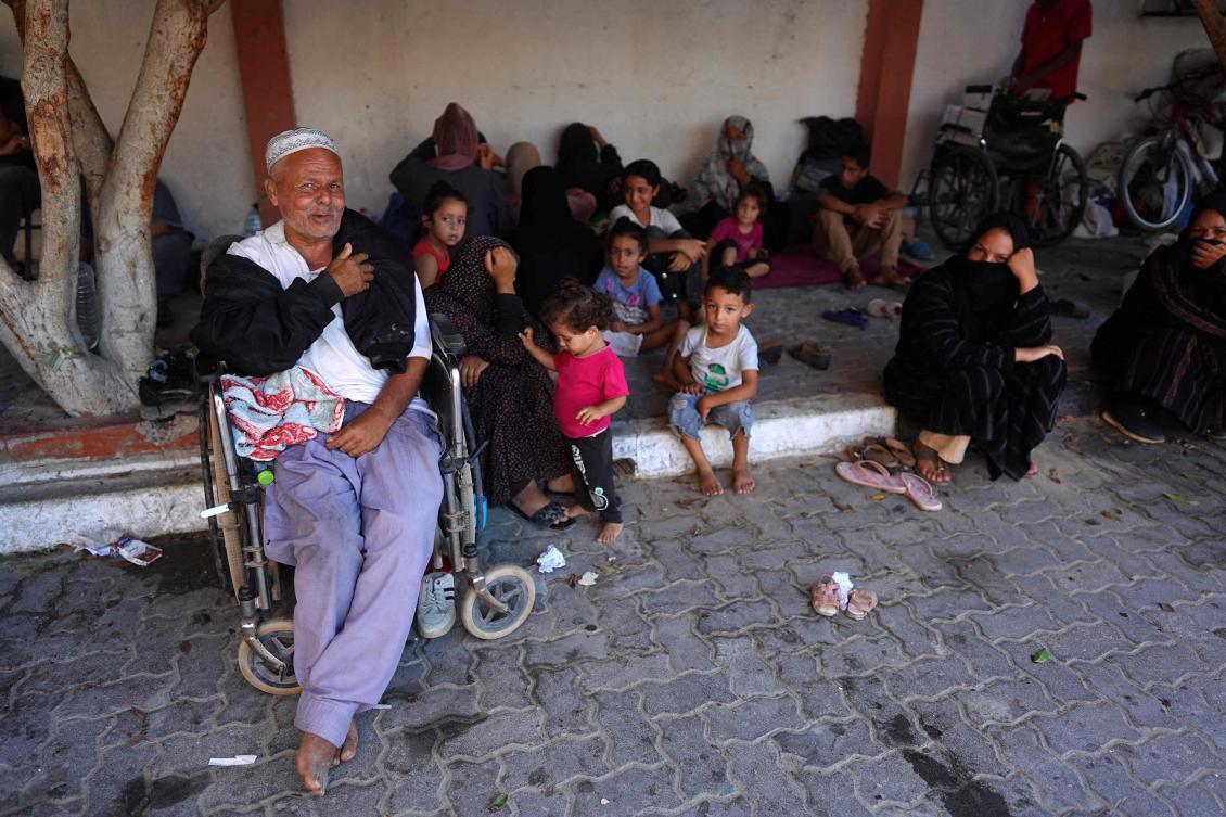 Families rest in the shade as summer temperatures reach over 30 degrees Celsius as thousands of Palestinians who fled following the Israeli army’s temporary evacuation order for parts of Khan Yunis, including the Al-Mawasi humanitarian zone, arrive in an another area of the southern Gaza Strip city (AFP)