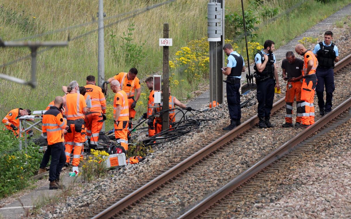 SNCF employees and French gendarmes inspect the scene of a suspected attack on the high speed railway network at Croiselles, northern France on July 26, 2024. (AFP)