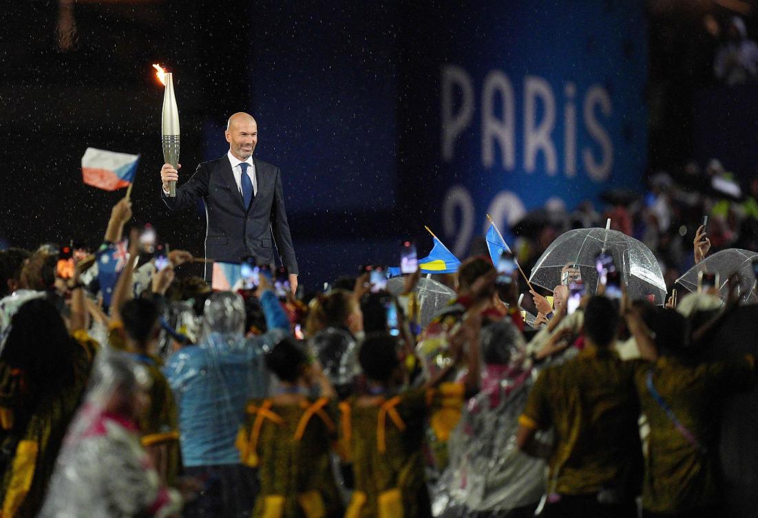 Former French football player Zinedine Zidane holds the Olympic torch during the opening ceremony of the Paris 2024 Olympic Games in Paris on Jul. 26, 2024. (AFP)