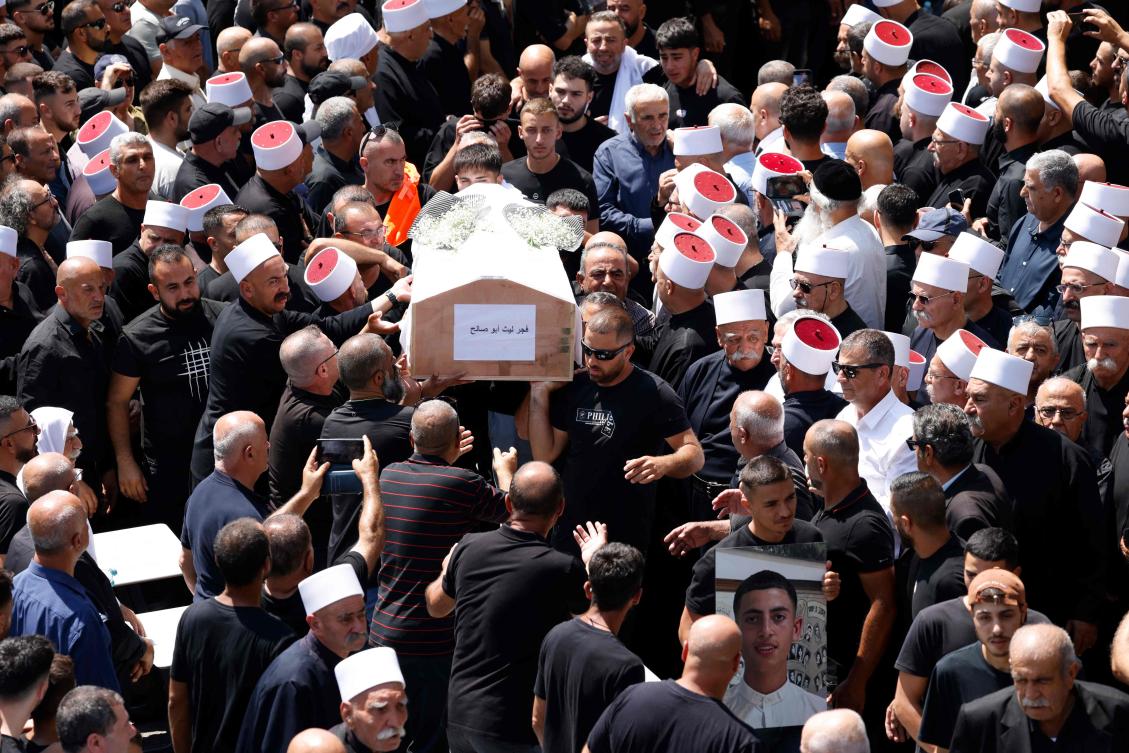 Mourners carry the coffin of person killed in a rocket strike from Lebanon a day earlier, during a mass funeral in the Druze town of Majdal Shams in the Israel-annexed Golan Heights, on July 28, 2024. (AFP)