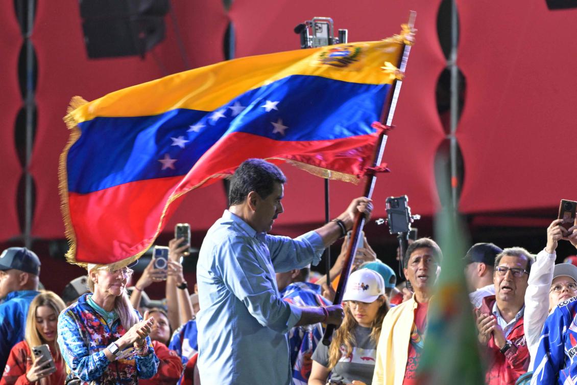 Venezuelan President and presidential candidate Nicolas Maduro waves a Venezuelan flag at his campaign closing rally in Caracas on July 25, 2024, ahead of Sunday's presidential election. (AFP)