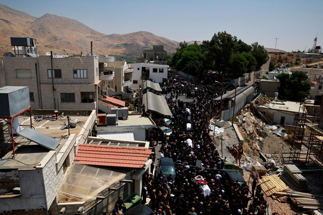 Mourners carry coffins, during the funeral of children who were killed at a soccer pitch by a rocket fired from Lebanon, in Majdal Shams, a Druze village in the Israeli-occupied Golan Heights, July 28, 2024. (Reuters)