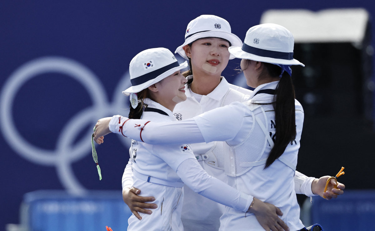 South Korea's Suhyeon Nam, Sihyeon Lim and Hunyoung Jeon react after winning gold in Women's Team Archery. (REUTERS)