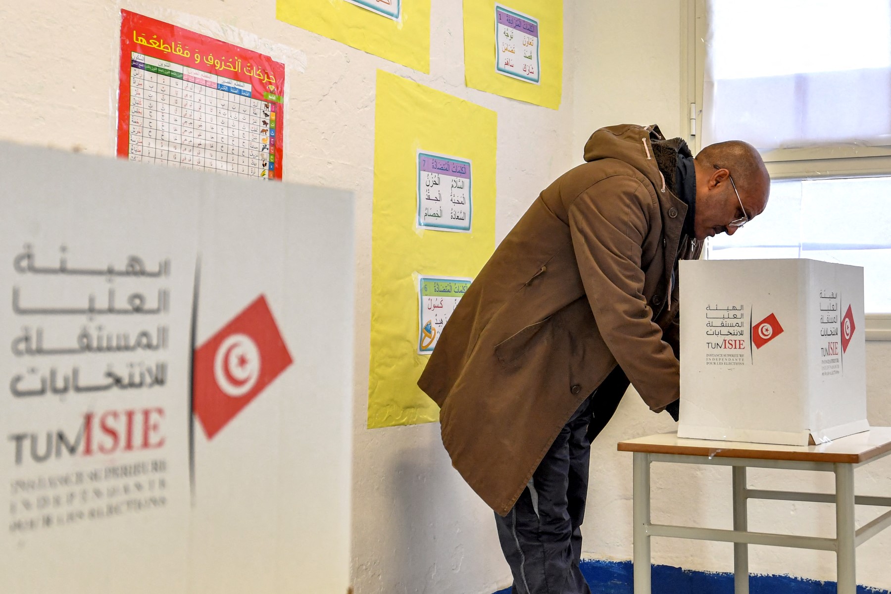 A voter ticks his ballot behind a privacy screen while voting at a polling station during the 2023 local elections in the locality of Mnihla in Ariana province on the outskirts of Tunis on December 24, 2023. (AFP)