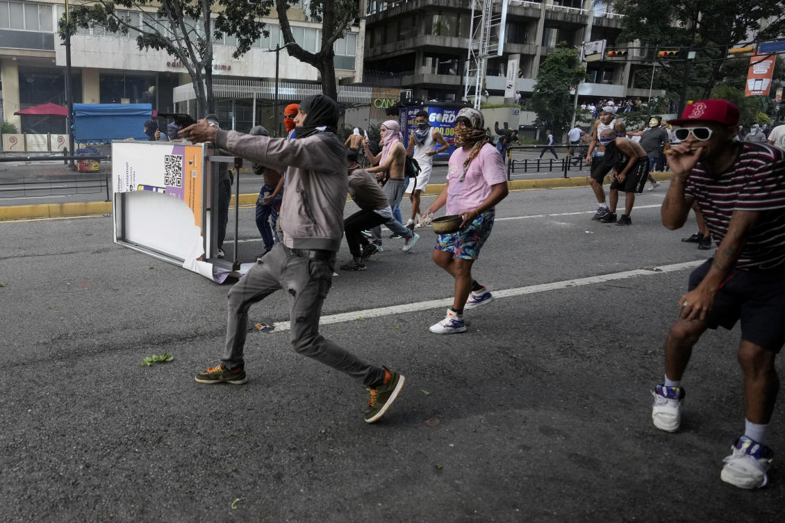 A protester aims a weapon during clashes with police amid demonstrations against the official election results declaring President Nicolas Maduro's reelection in Caracas, Venezuela, Monday, July 29, 2024, the day after the vote. (AP)