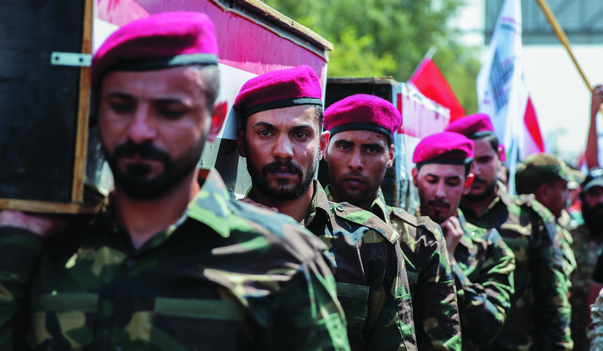 Members of Iraqi Popular Mobilization Forces (PMF) carry the mock coffins of fellow members of PMF, who were killed by US air strikes on the Syria-Iraq border, during a symbolic funeral in Baghdad, Iraq, June 29, 2021. (REUTERS file photo)