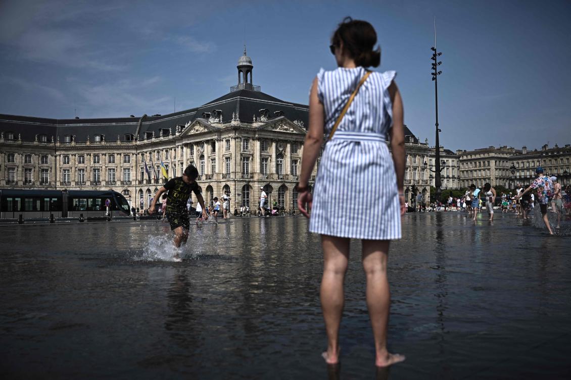 People cool off on the “Miroir d’Eau” water feature (Reflecting Water) in Bordeaux, southwestern France on July 30, 2024, as a heatwave spreads across southern areas of the country. (AFP)