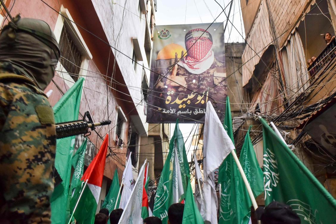 Demonstrators wave flags during a protest on July 31, 2024 in Beirut’s Burj Al-Barajneh camp for Palestinian refugees, denouncing the killing of the leader of the militant Hamas group. (AFP)