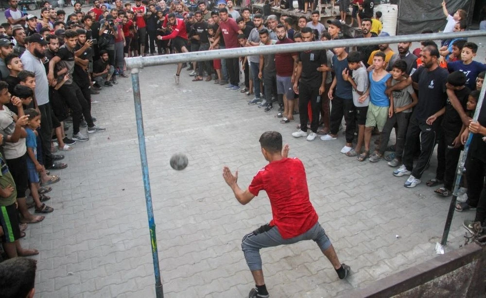 A displaced Palestinian takes a penalty during a football match at an UNRWA school, Jabalia, Gaza, July 23, 2024. (Reuters)