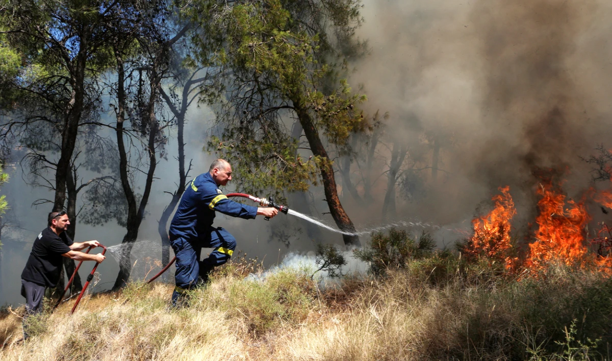 A firefighter works to extinguish a wildfire burning in Keratea, near Athens, Greece, Sunday. Greece has scaled up its preparations this year. (Reuters)