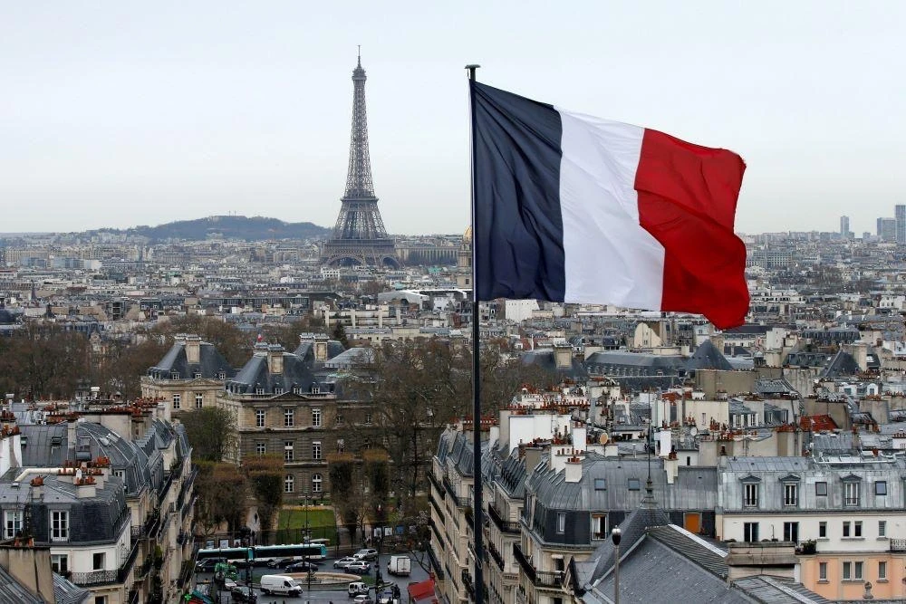 The French flag flies above the Paris skyline with the Eiffel Tower in the distance, Paris, France, March 30, 2016. (Reuters)