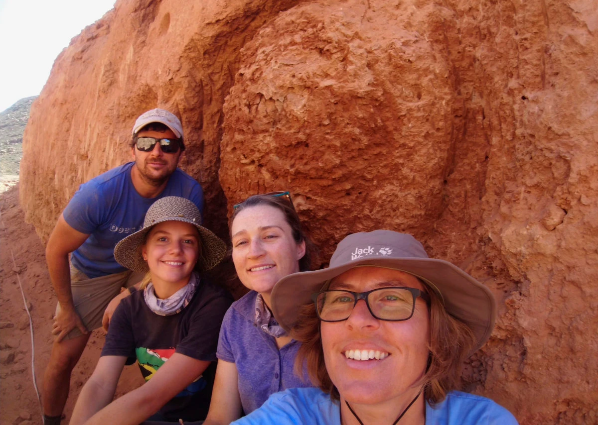 Stellenbosch University researcher Michele Francis, right, and other researchers, pose for a selfie, next to an ancient termite mound in Namaqualand, South Africa. (Michele Francis via AP)