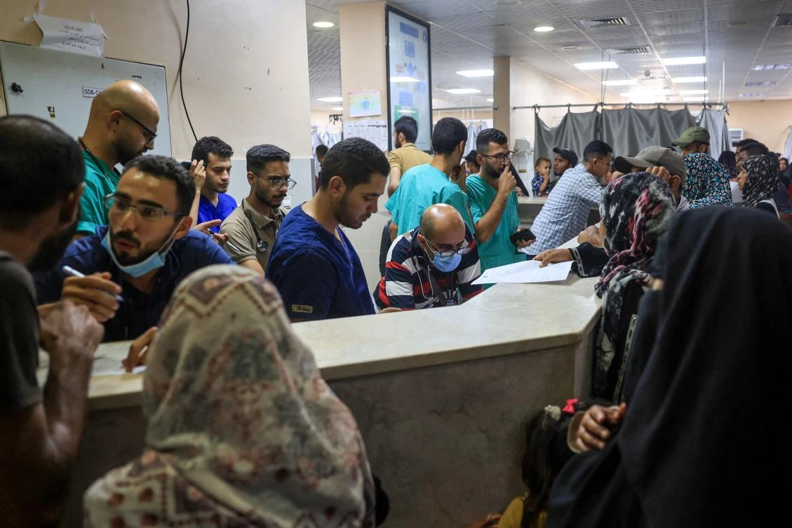 Palestinian medics and civilians stand at Nasser hospital after patients were transferred from the European Gaza Hospital following evacuation orders by the Israeli army, in Khan Yunis in the southern Gaza Strip on July 3, 2024, amid the ongoing conflict between Israel and the Palestinian Hamas militant group. (AFP)