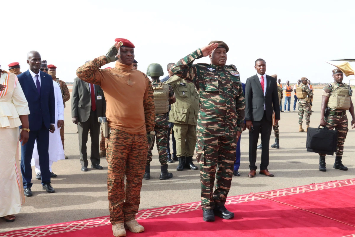 Niger's General Abdourahamane Tiani (R) salutes next to his Burkinabe counterpart Captain Ibrahim Traore (L) upon his arrival in Niamey on July 5, 2024. (AFP)