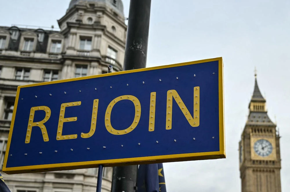 There have been calls for the UK to rejoin the European Union. Above, a Rejoin placard in front of the Elizabeth Tower at the Palace of Westminster in central London on Jan. 31, 2024. (AFP)