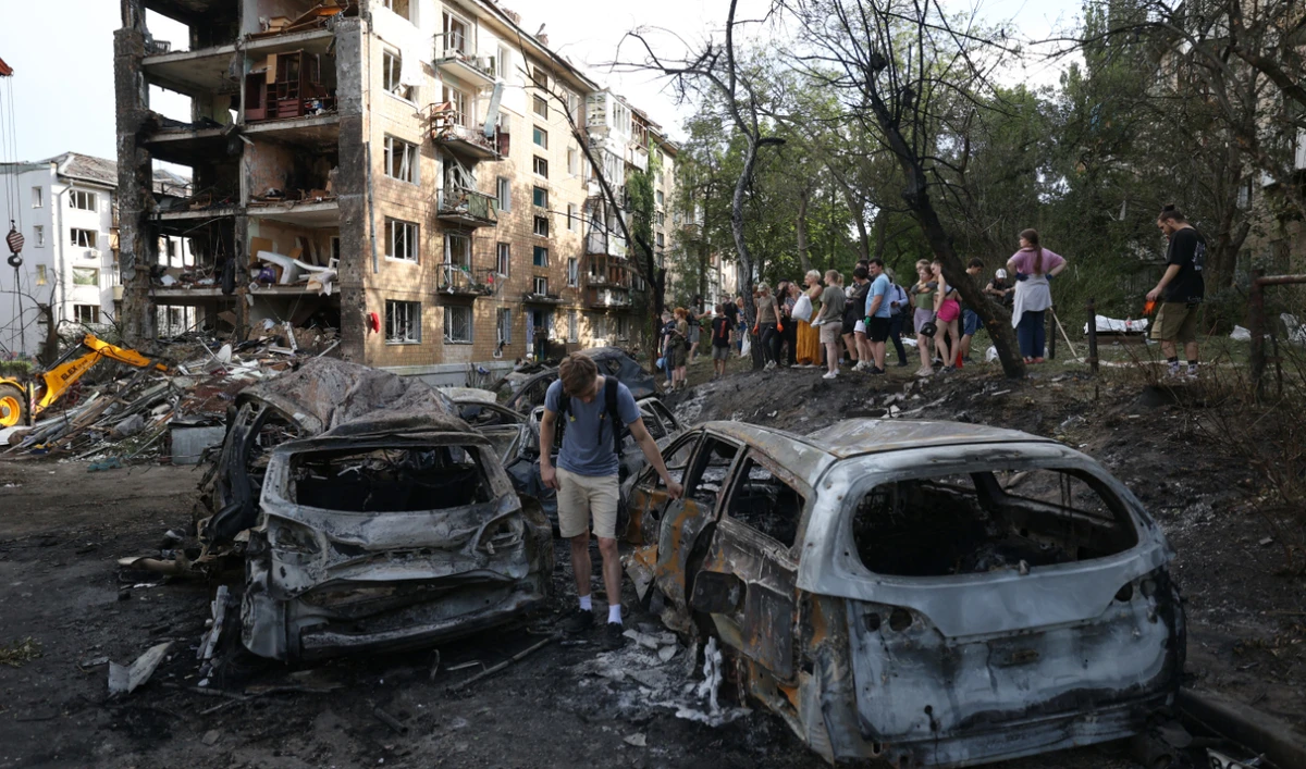 A young man examines his car destroyed by a missile strike in Kyiv, on July 8, 2024. (AFP)