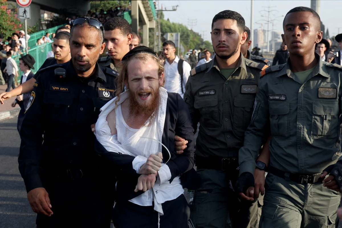 Israeli police detain a protester as they they try to disperse Ultra-Orthodox Jews blocking a highway during a protest against possible changes regarding the laws on the military draft from which the Ultra-Orthodox community has traditionally been exempt (AFP)