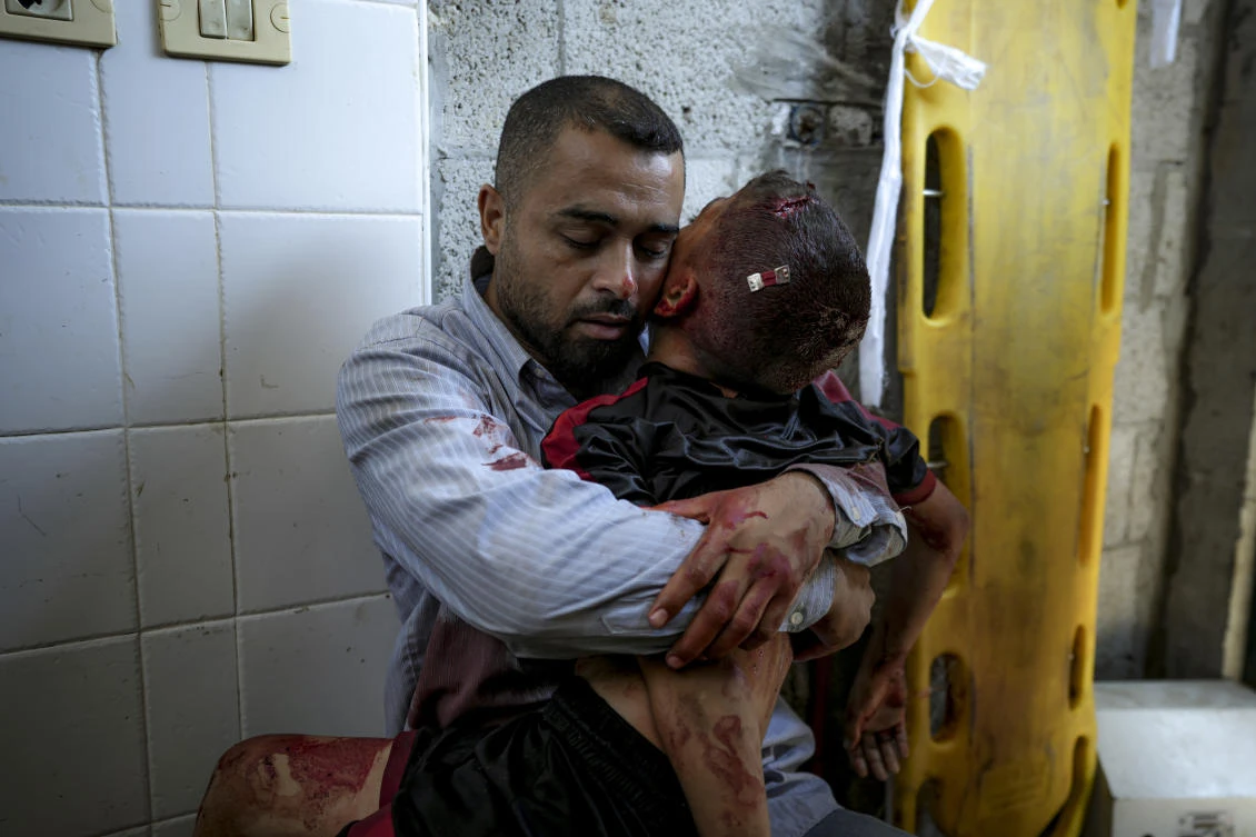 A Palestinian man holds the body of his child killed in the Israeli bombardment of the Gaza Strip, at a hospital morgue in Deir al-Balah, on Jul. 9, 2024. (AP)