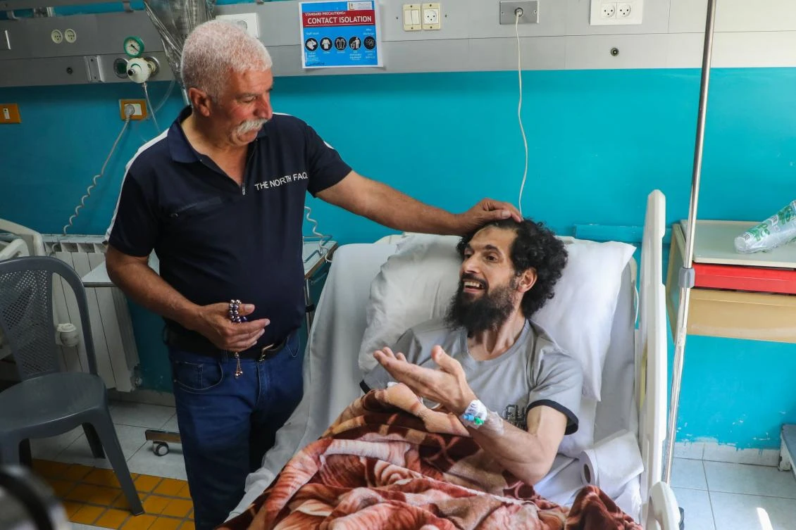 Khalil Abayat, the father of Muazzaz Khalil Abayat, a 37-year-old Palestinian from Bethlehem, visits his son in a hospital following his release days earlier after being detained by Israeli forces, in Beit Jala in the Israeli occupied West Bank, on July 11, 2024. (AFP)