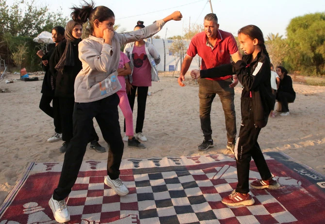 Palestinian boxing coach Osama Ayoub trains girls on boxing near a tent camp sheltering displaced people, amid Israel-Hamas conflict, in Khan Younis in the southern Gaza Strip July 10, 2024. (REUTERS)