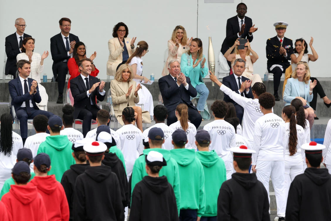 The Olympic torch relay is joining up with thousands of troops marching in Paris beneath roaring fighter jets to mark Bastille Day. (REUTERS)