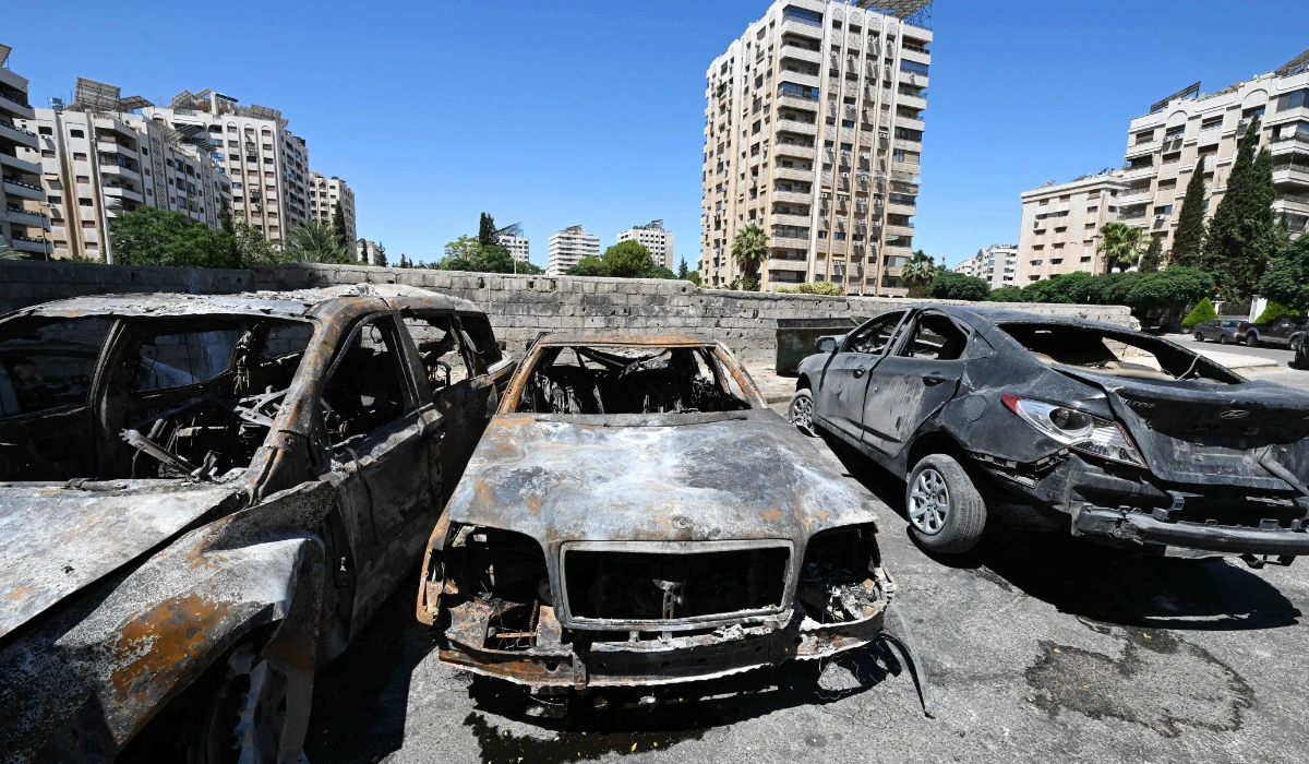 Charred vehicles litter a parking area in the aftermath of Sunday’s Israeli strike in the neighborhood of Kafr Sousse in Damascus. (AFP)
