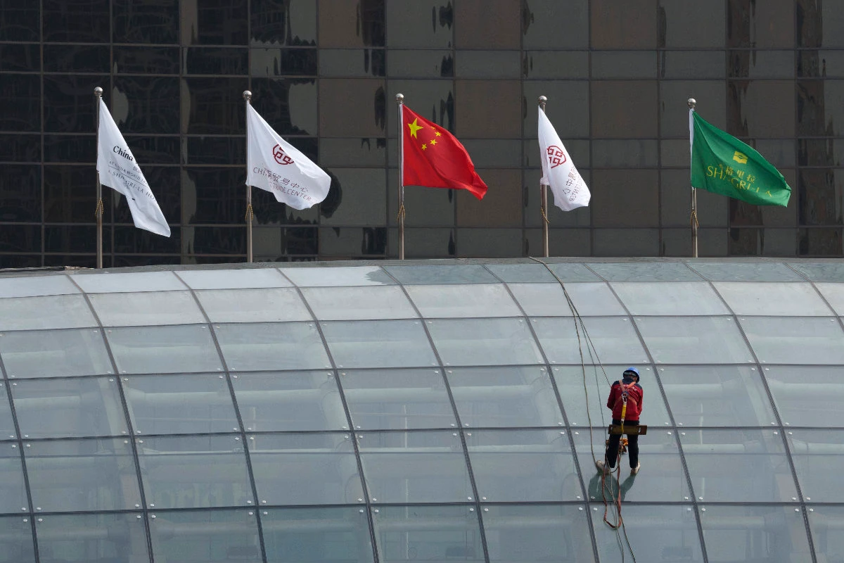 A worker descends on the rooftop of a building at the central business district in Beijing, China on July 15, 2024. China's ruling Communist Party is starting a four-day meeting Monday that is expected to lay out a strategy for self-sufficient economic growth. (AP)