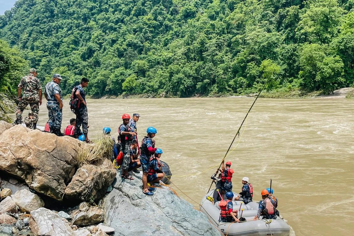 Nepali rescue teams search for survivors in the Trishuli River after monsoon rains triggered a landslide swept two buses off a highway and into the river. (AFP)