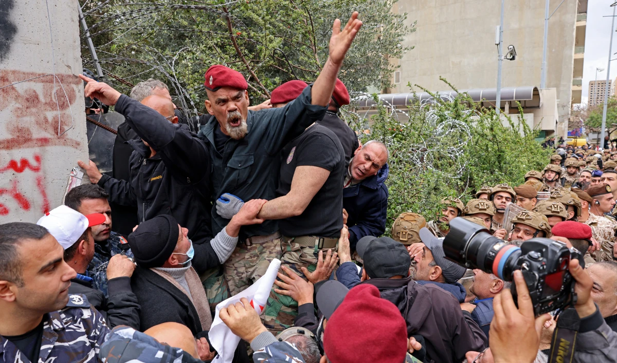 Retired servicemen remove razor wire barricade outside Lebanon’s central bank during a demonstration demanding inflation-adjustments to their pensions, in Beirut on March 30, 2023. (AFP/File)