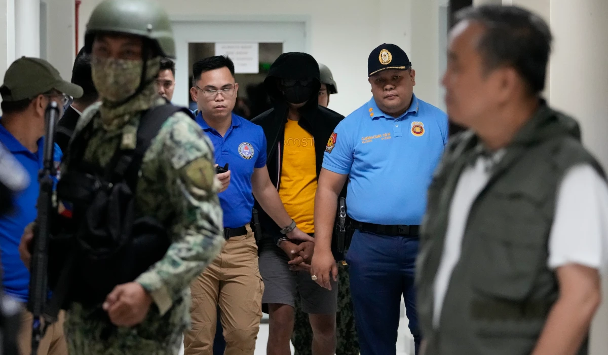 A suspect in the killing of two Australian nationals and a Filipino is escorted under tight security following his surrender in Tagaytay City, Cavite on July 17, 2024. (AP)
