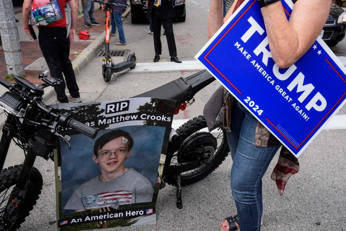 A woman walks by a poster depicting Thomas Matthew Crooks, the man that attempted to assassinate former President Donald Trump, during the third day of the 2024 Republican National Convention in Milwaukee on July 17, 2024. (AP)