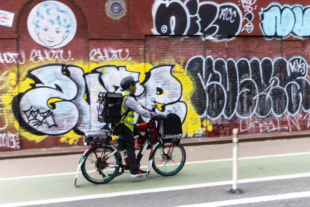 Sergio Solano, an immigrant from Mexico, rides his bicycle while making a delivery on June 21 in New York. (AP)