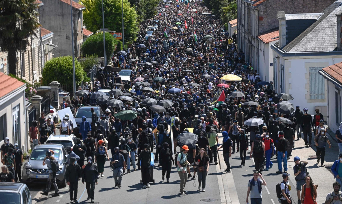 Protesters walk among the houses of a village during a demonstration against the construction of giant water reservoir (mega-bassine) in La Rochelle, western France, on July 20, 2024. (AFP)