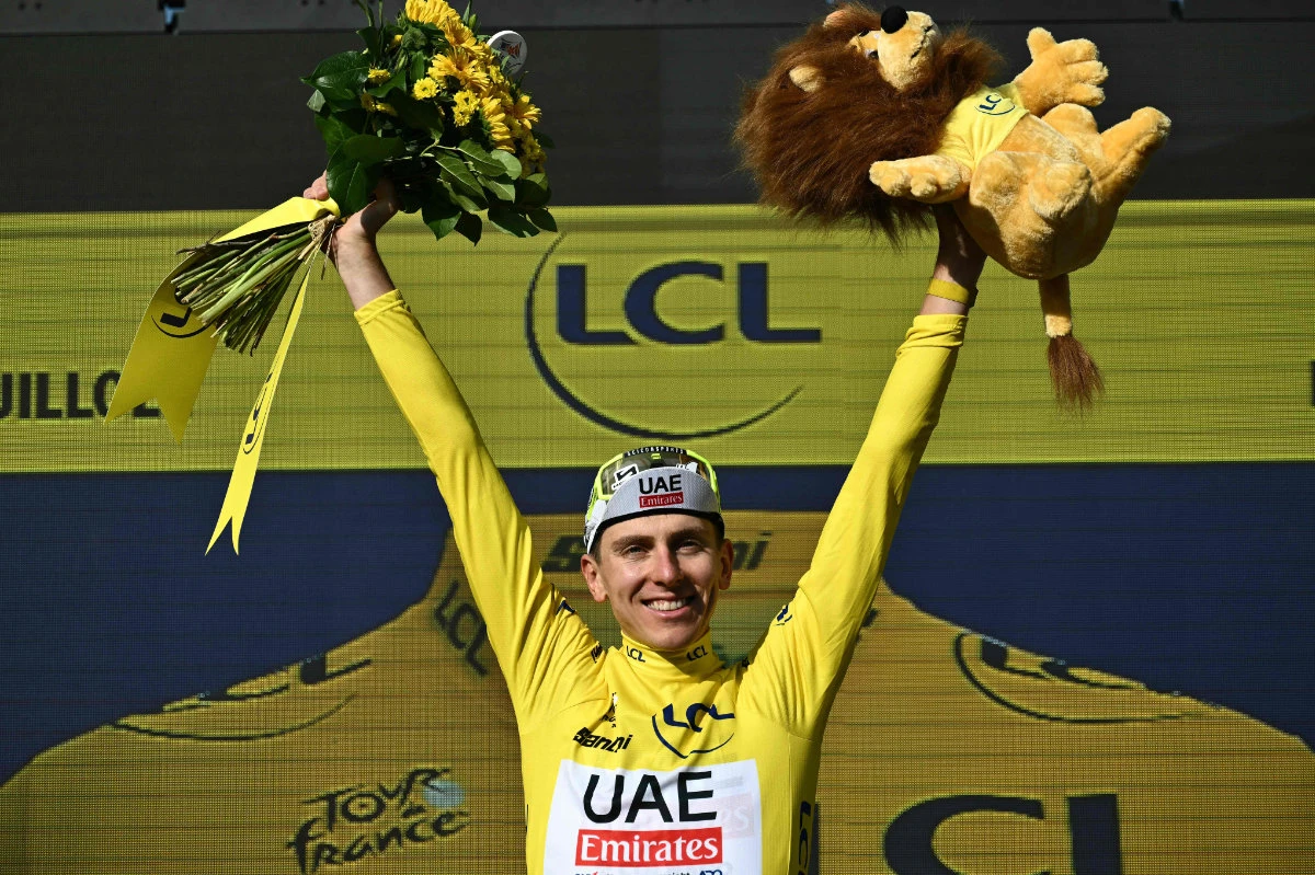 UAE Team Emirates leader, Slovenian rider Tadej Pogacar, celebrates on the podium with the overall leader's yellow jersey after the 20th stage of the Tour de France cycling race, 132.8 km between Nice and Col de la Couillole, southeastern France, on July 20, 2024. (AFP)