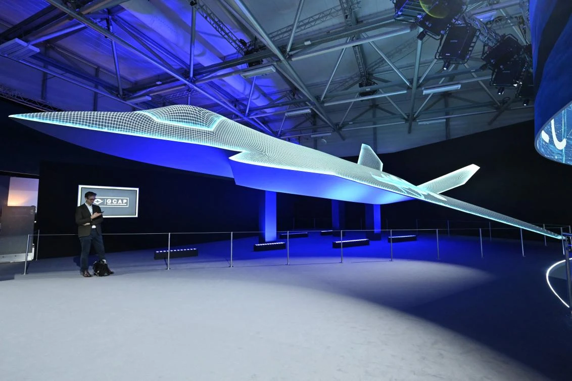A person stands beside the Global Combat Air Programme (GCAP) 6th generation fighter jet concept design on the opening day of the Farnborough International Airshow 2024 on July 22, 2024. (AFP)
