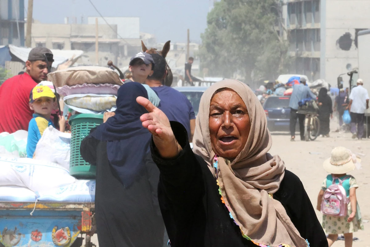 Palestinian woman gestures as others flee the eastern part of Khan Younis after they were ordered by Israeli army to evacuate their neighborhoods. (Reuters)