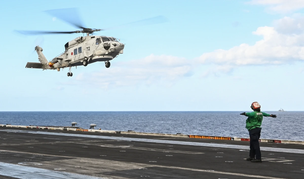 A Japan Maritime Self-Defense Force SH-60K helicopter lands on the deck of the USS Carl Vinson aircraft carrier during a three-day maritime exercise between the US and Japan in the Philippine Sea on January 31, 2024. (AFP/File)