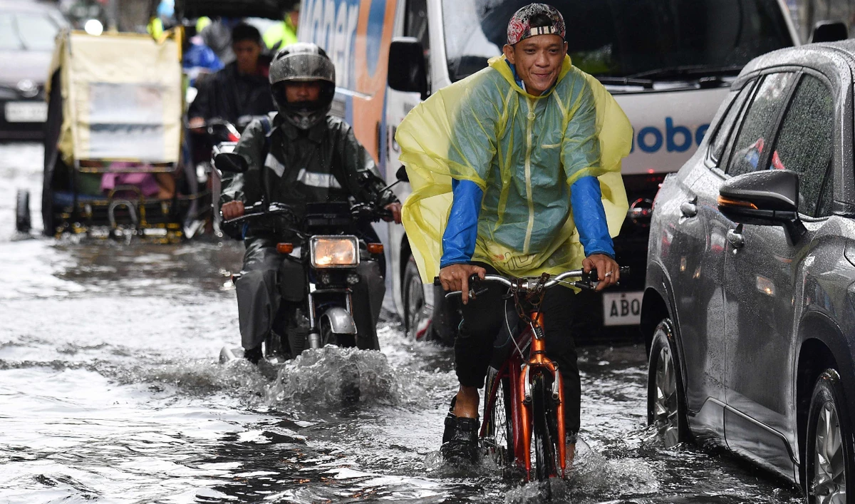 A cyclist rides through through a flooded street in Manila on July 23, 2024, amid heavy rains brought about by Typhoon Gaemi. (AFP)