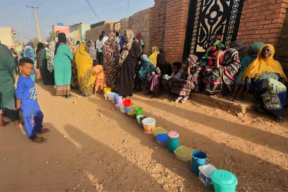 Residents wait to collect food in containers from a soup kitchen in Omdurman, Sudan on Mar 11, 2024. (Reuters/File)