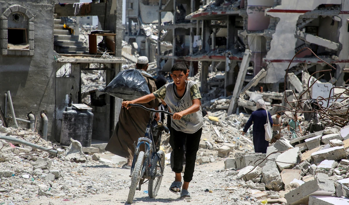 A Palestinian pushes a bicycle as he walks past the rubble of houses destroyed during the Israeli military offensive, amid Israel-Hamas conflict, in Khan Younis in the southern Gaza Strip July 10, 2024. (REUTERS/File)