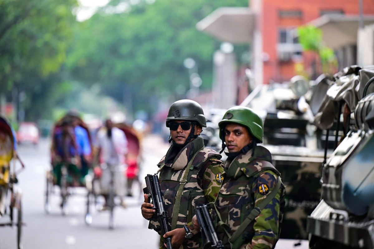 Bangladeshi security forces stand guard near the country's Secretariat as a curfew is relaxed after days of protests, in Dhaka. (AFP)