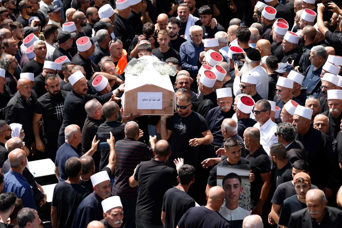 Mourners carry the coffin of person killed in a rocket strike from Lebanon a day earlier, during a mass funeral in the Druze town of Majdal Shams in the Israel-annexed Golan Heights, on July 28, 2024. (AFP)