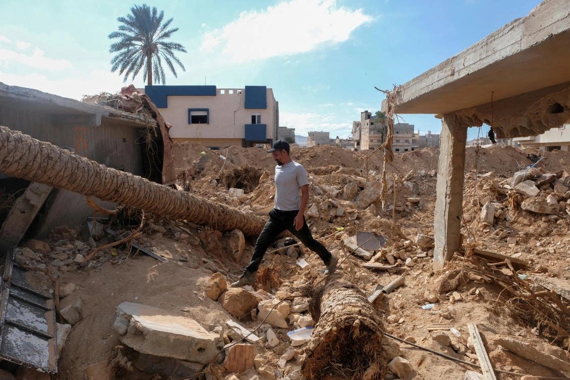 Abdul Salam Ibrahim Al-Qadi, 43 years old, walks on the rubble in front of his house, searching for his missing father and brother after the deadly floods in Derna, Libya. (File/Reuters)