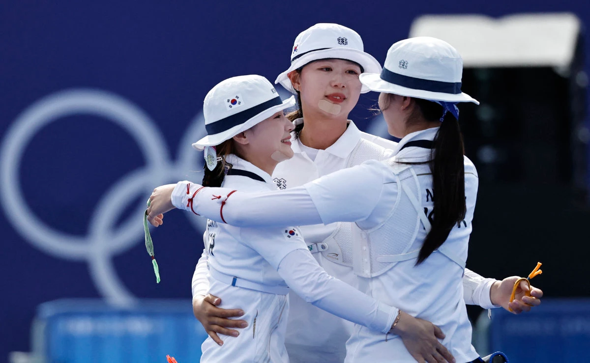 South Korea's Suhyeon Nam, Sihyeon Lim and Hunyoung Jeon react after winning gold in Women's Team Archery. (REUTERS)
